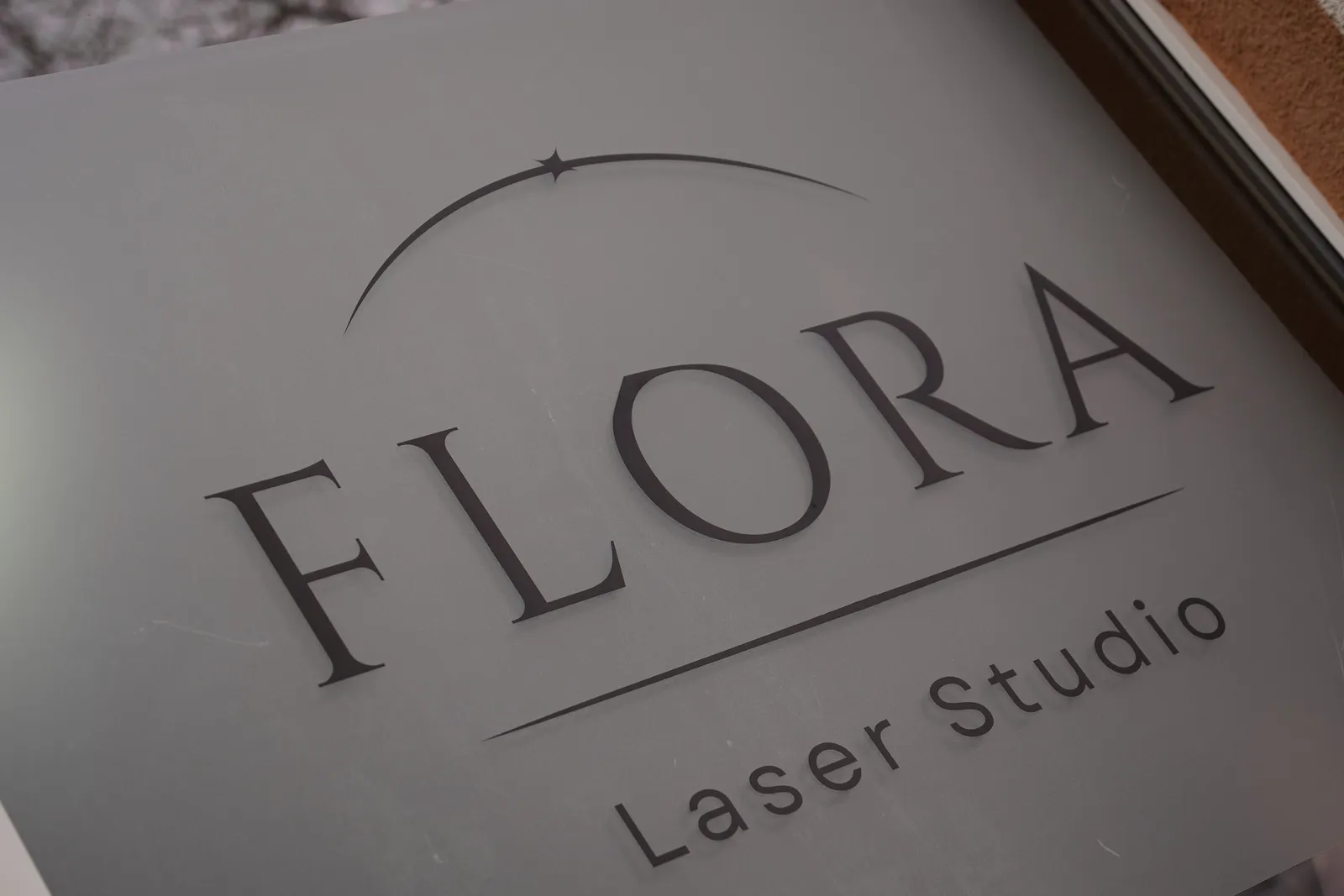 Witryna studia z matową folią i logo FLORA Laser Studio
